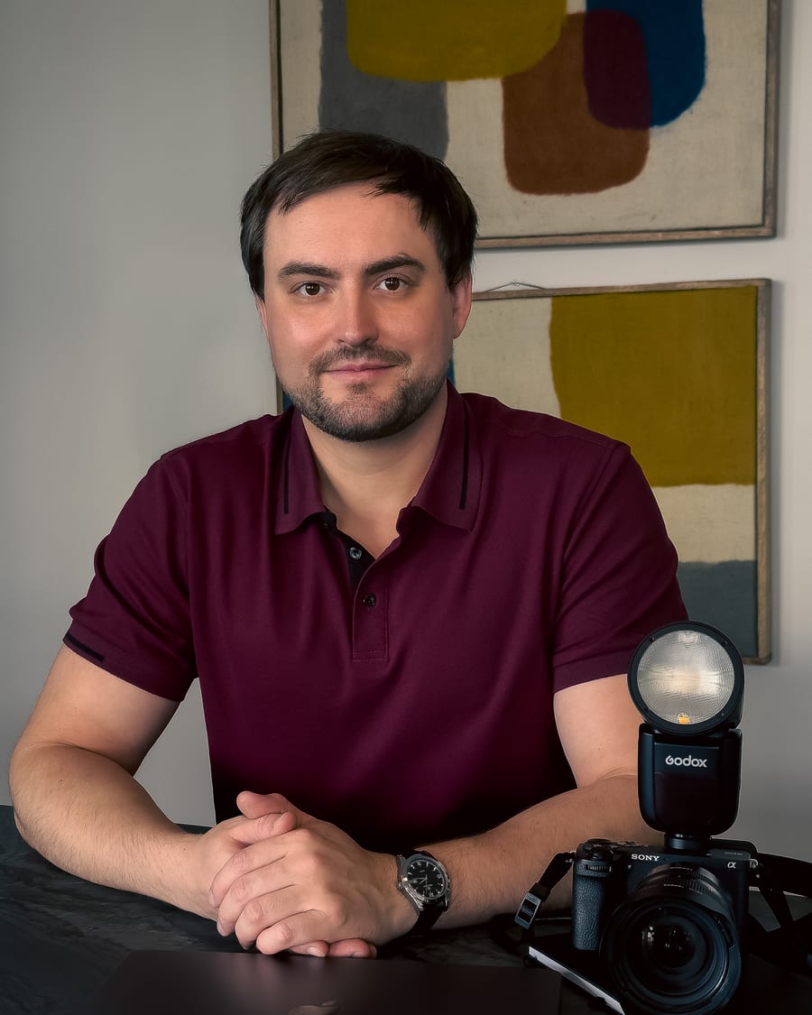 Viktor Kovalov, photographer, seated with camera in studio